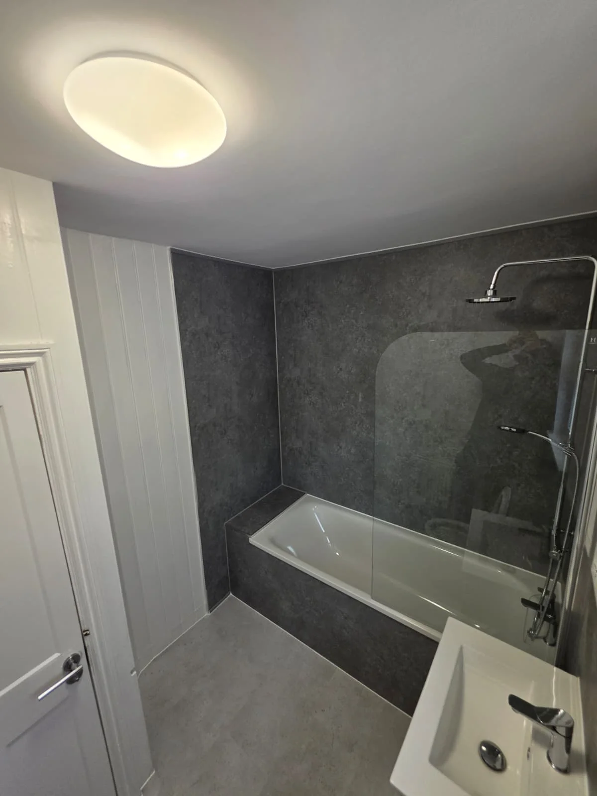 Completed Lancaster Road bathroom renovation with grey tiles and a glass shower screen