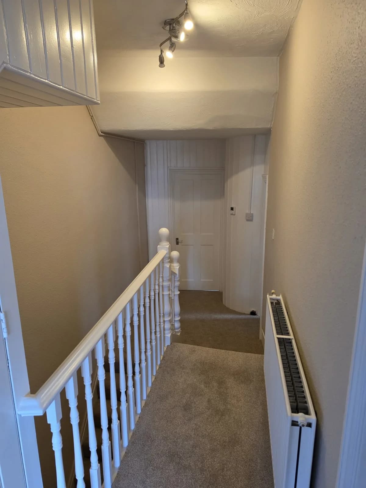 Landing with neutral carpet and white balustrade at Lancaster Road